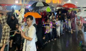 Doc.Peserta pawai obor berjalan menyusuri jalanan RW 03 sambil melantunkan shalawat. Meski hujan turun, semangat mereka tetap tinggi dalam menyambut bulan penuh berkah, dengan pengawalan dari aparat keamanan untuk memastikan kelancaran acara. (Kebon Kelapa, 27/2/2025 – Foto Dokumentasi: Maulana Syarif).