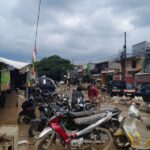 Doc. Kondisi banjir yang menggenangi ruas Jalan Pasar Bojong Kulur, Gunung Putri, Kabupaten Bogor, tampak menghambat aktivitas warga. Beberapa kendaraan sepeda motor terlihat terparkir di tengah genangan air, sementara pengendara dan pejalan kaki berusaha melewati jalan yang tergenang. (Bogor, 4/3/2025 – Foto Dokumentasi: M. Ismail).