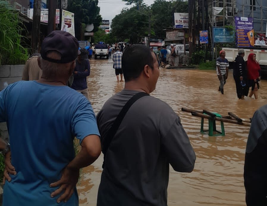 Doc. Sejumlah warga berdiri di pinggir jalan, mengamati situasi banjir dengan penuh keprihatinan. Mereka mencermati dampak yang ditimbulkan akibat sisa banjir yang menggenangi kawasan sekitar, seraya berharap adanya tindakan cepat dari pihak berwenang untuk mengatasi kondisi ini. (Bogor, 4/3/2025 – Foto Dokumentasi: M. Ismail).