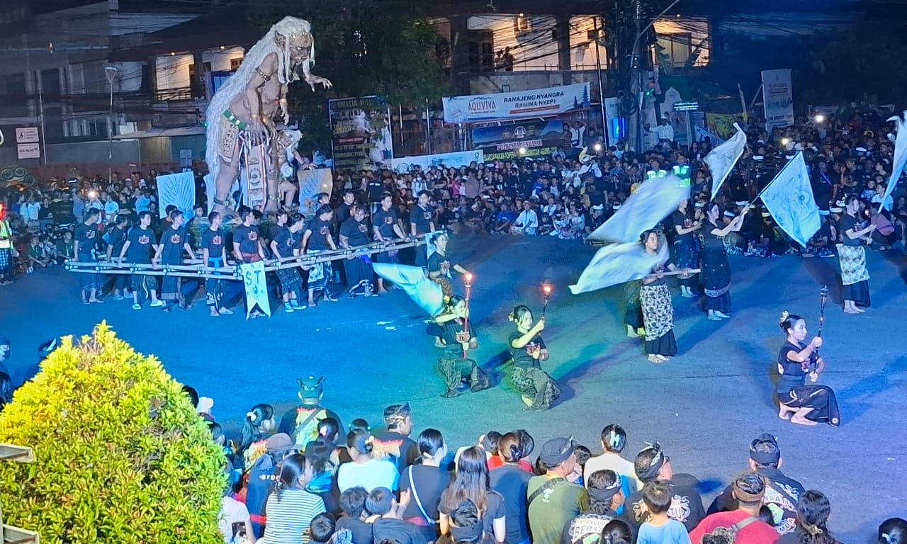 Doc. Pemandangan keseluruhan parade ogoh-ogoh yang berlangsung meriah di Padang Sambian. Kerumunan masyarakat tampak memenuhi area sekitar, menyaksikan iring-iringan ogoh-ogoh dan pertunjukan seni yang menghiasi malam sebelum Hari Raya Nyepi. (Bali, 28/3/2025 - Foto Dokumentasi: Witanto).
