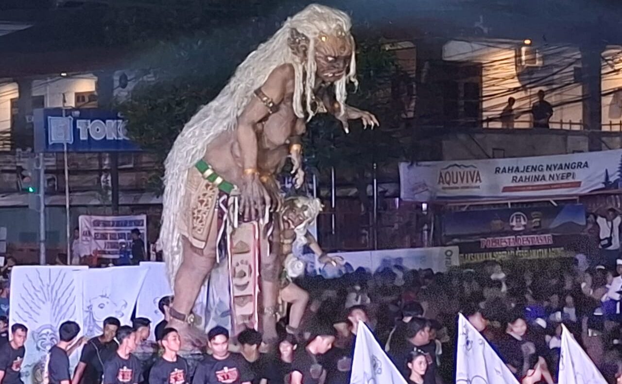 Doc. Sebuah ogoh-ogoh berwujud raksasa dengan rambut panjang putih diarak dalam parade di Padang Sambian. Para pemuda dari banjar setempat terlihat mengangkat ogoh-ogoh dengan penuh semangat di tengah kerumunan penonton. (Bali, 28/3/2025 - Foto Dokumentasi: Witanto).
