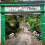 Doc. Gerbang masuk Desa Kaduagung, Kecamatan Karangkancana, Kabupaten Kuningan (siang hari), dengan latar belakang jembatan yang menjadi sorotan warga terkait minimnya penerangan jalan. Warga berharap pemerintah segera menangani permasalahan ini demi keselamatan bersama. (Kuningan, Jawa Barat, 4/4/2025 – Foto Dokumentasi: Muh. Ismail).