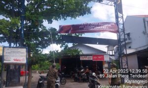 Doc. Petugas Satpol PP Kabupaten Banyuwangi menurunkan spanduk bertema antikorupsi yang dipasang oleh PUSKAPTIS di kawasan Jalan Piere Tendean, Karangrejo, Banyuwangi, Jawa Timur, Selasa (22/4/2025). Spanduk tersebut berisi ajakan moral untuk menolak praktik penyalahgunaan anggaran. Penurunan spanduk ini menuai kritik dari PUSKAPTIS yang menilai tindakan tersebut sebagai pembatasan ruang ekspresi publik. (Foto Dokumentasi: Ari).