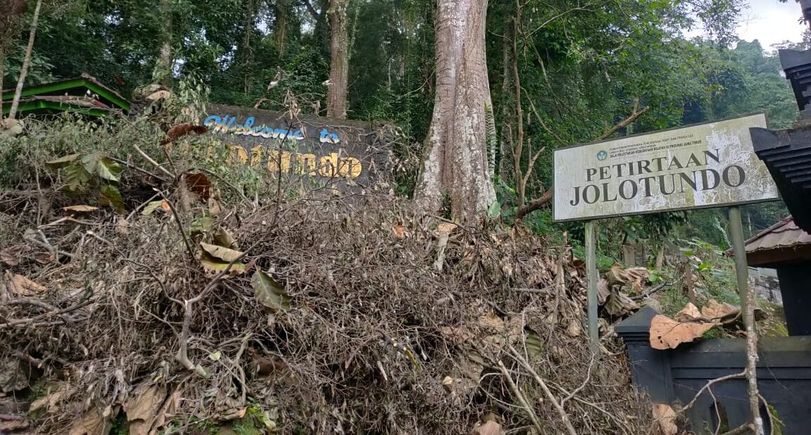 Doc. Papan penanda kawasan Petirtaan Jolotundo di lereng Gunung Penanggungan, Mojokerto, tampak di antara rimbunnya pepohonan. Situs ini menjadi destinasi spiritual dan wisata sejarah yang penting di Jawa Timur. (Foto Dokumentasi: Eko Wahyu – kawanjarinews.com).