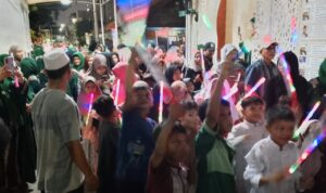 Doc. Anak-anak dan warga tumpah ruah di depan Masjid Raudhah, Jakarta Pusat, sambil mengangkat obor dan tongkat lampu warna-warni pada malam Pawai Obor menyambut Tahun Baru Islam 1447 H. Kegiatan ini berlangsung meriah dengan antusiasme tinggi dari berbagai kalangan masyarakat. (Foto Dokumentasi: Maulana Syarif).