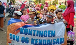 Doc. Siswa dan Siswi SDN 06 Kendalsari mengikuti pawai dengan penuh semangat, mengenakan berbagai kostum profesi dan adat, sambil membawa spanduk bertuliskan "Kontingen SDN 06 Kendalsari" dalam rangka memeriahkan peringatan Hari Kemerdekaan Republik Indonesia. (Foto: Soleh).