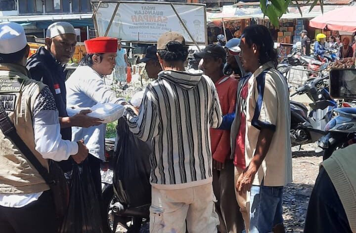 Doc. Anggota Forum Cakar Sriwijaya DPD Kota Palembang membagikan paket makanan siap saji kepada masyarakat dalam kegiatan Jumat Berkah di Pasar 26, Jalan Merdeka, Talang Semut, Kecamatan Bukit Kecil, Palembang, Jumat (22/8/2025). (Foto: Rosal – kawanjarinews.com).