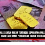 Doc. Ilustrasi emas batangan Antam yang ditumpuk di atas lembaran uang pecahan Rp100.000. Visual ini menggambarkan pergerakan harga emas di tengah dinamika ekonomi nasional dan fluktuasi nilai tukar rupiah terhadap dolar AS. Gambar ini bersifat ilustratif. Ilustrasi digunakan untuk memberikan konteks isu ekonomi, investasi masyarakat, dan stabilitas nilai tukar rupiah. (NR | KawanJariNews.com).