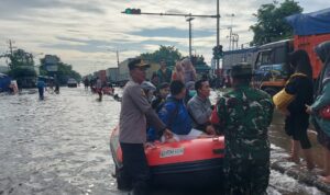 Doc. Personel Polsek Genuk bersama anggota TNI membantu proses evakuasi warga menggunakan perahu karet di kawasan Genuksari, Kecamatan Genuk, Kota Semarang, setelah wilayah tersebut terendam banjir akibat hujan deras yang mengguyur sejak Selasa (21/10/2025). (Foto: Sriyanto).