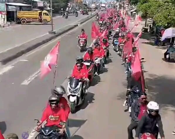 Doc. Ratusan buruh berkonvoi menggunakan sepeda motor sambil membawa bendera serikat pekerja dalam aksi damai menuntut kenaikan UMK Brebes, Rabu siang. (Foto: Taufik Hidayat | KawanJarinews.com).