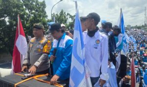 Doc. Kapolres Serang AKBP Condro Sasongko berdiri di atas mobil komando peserta aksi untuk memantau langsung jalannya unjuk rasa buruh ASPSB selama perjalanan dari Kawasan Industri Modern Cikande menuju Pendopo Bupati Serang. Aparat kepolisian turut melakukan pengawalan ketat di sepanjang rute aksi. (Foto: Moh. Ismail).