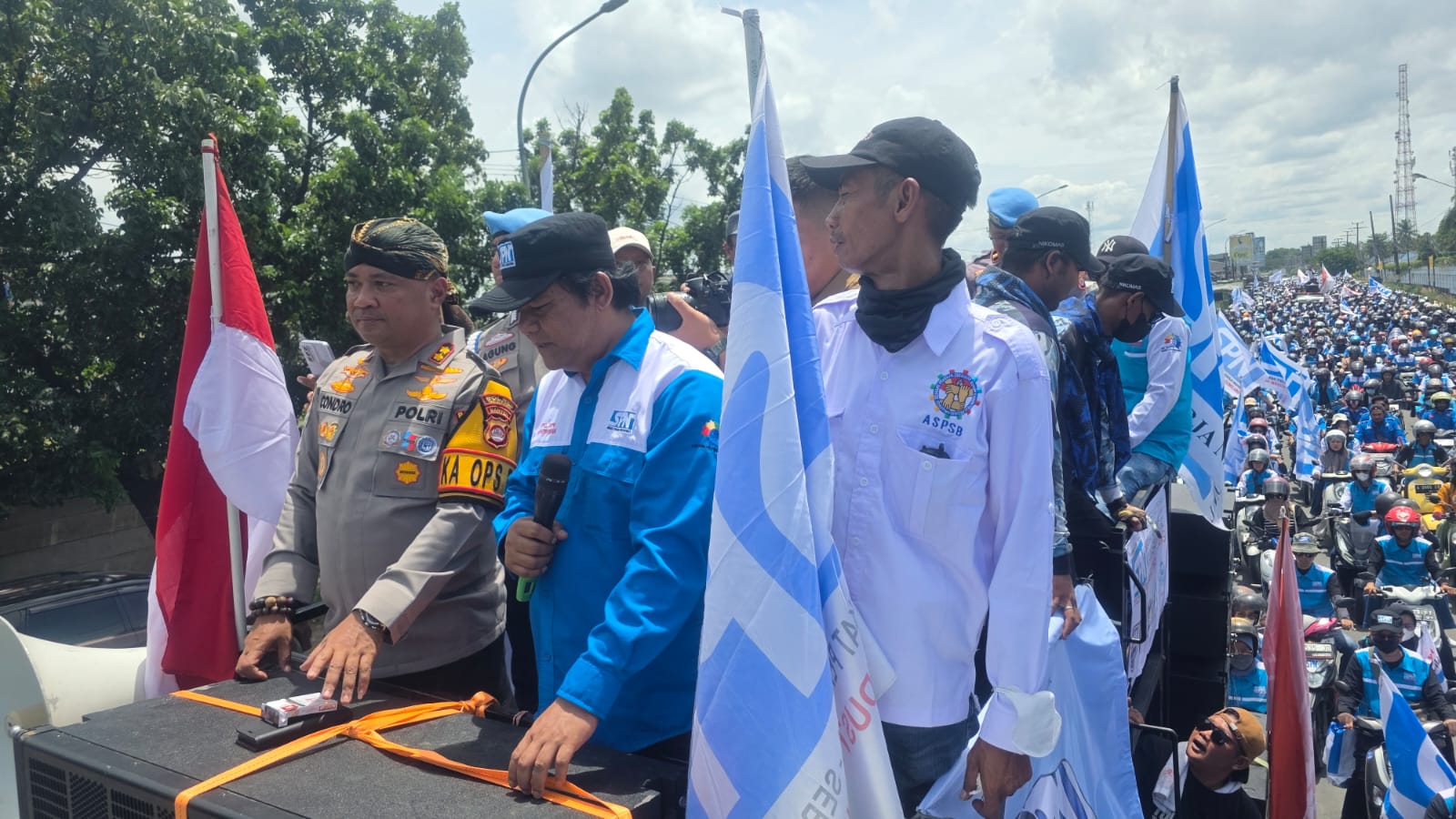 Doc. Kapolres Serang AKBP Condro Sasongko berdiri di atas mobil komando peserta aksi untuk memantau langsung jalannya unjuk rasa buruh ASPSB selama perjalanan dari Kawasan Industri Modern Cikande menuju Pendopo Bupati Serang. Aparat kepolisian turut melakukan pengawalan ketat di sepanjang rute aksi. (Foto: Moh. Ismail).