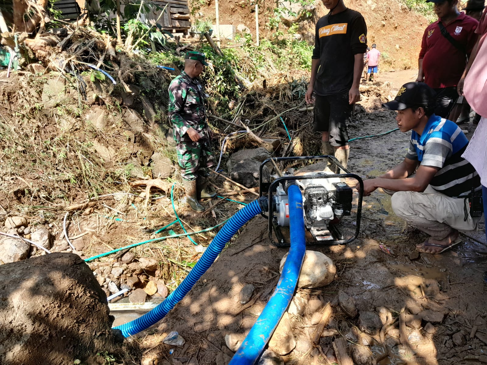 Doc. Proses gotong royong antara petugas dan warga dalam membersihkan lumpur serta sampah bawaan banjir di wilayah Kampung Cibago, Desa Mayang.