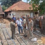 Doc. Petugas Satpol PP Kabupaten Kuningan meninjau lokasi pembangunan tower Base Transceiver Station (BTS) di Desa Pajawan Kidul, Kecamatan Lebakwangi, Kabupaten Kuningan, pada Senin (29/12/2025), sebelum memutuskan penghentian sementara aktivitas pembangunan untuk pemeriksaan lanjutan terkait perizinan PBG. (Foto: Moh. Ismail).