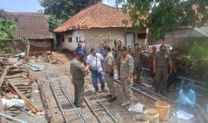 Doc. Petugas Satpol PP Kabupaten Kuningan meninjau lokasi pembangunan tower Base Transceiver Station (BTS) di Desa Pajawan Kidul, Kecamatan Lebakwangi, Kabupaten Kuningan, pada Senin (29/12/2025), sebelum memutuskan penghentian sementara aktivitas pembangunan untuk pemeriksaan lanjutan terkait perizinan PBG. (Foto: Moh. Ismail).