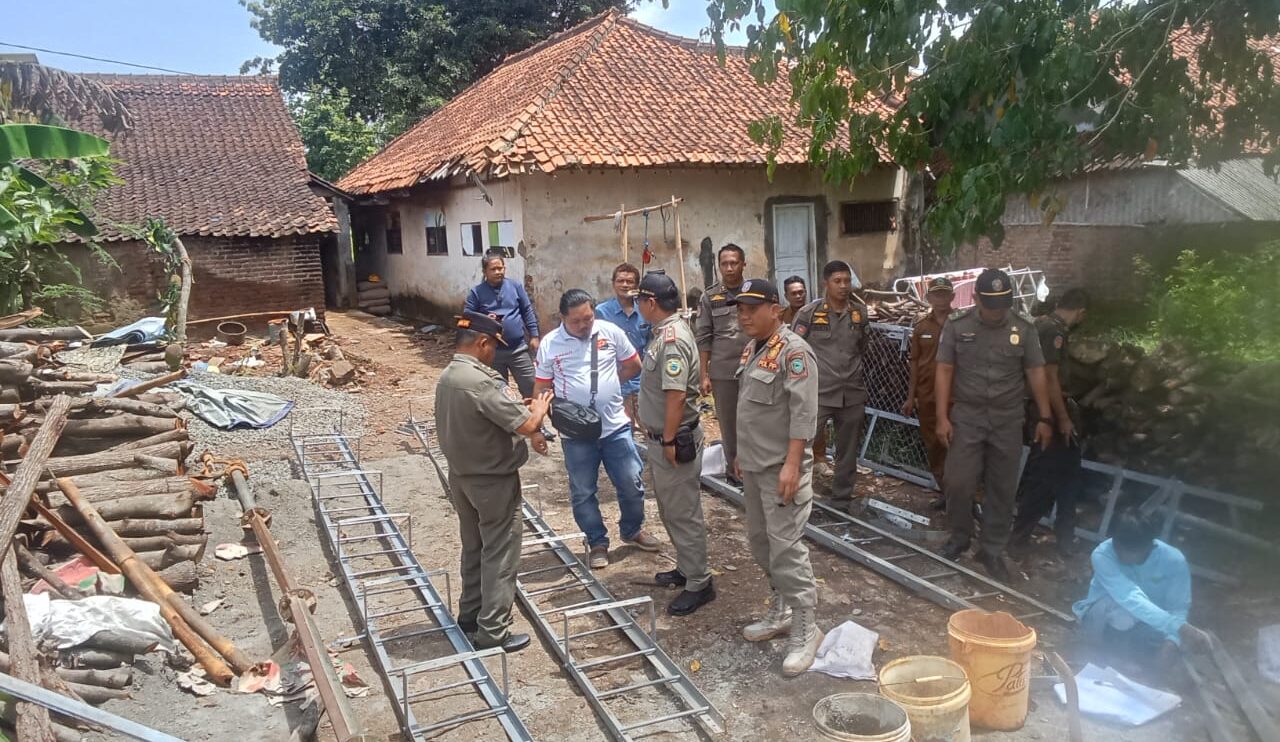 Doc. Petugas Satpol PP Kabupaten Kuningan meninjau lokasi pembangunan tower Base Transceiver Station (BTS) di Desa Pajawan Kidul, Kecamatan Lebakwangi, Kabupaten Kuningan, pada Senin (29/12/2025), sebelum memutuskan penghentian sementara aktivitas pembangunan untuk pemeriksaan lanjutan terkait perizinan PBG. (Foto: Moh. Ismail).