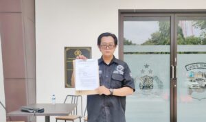 Doc. Eko Wahyu Pramono, S.Ak., saat menunjukkan bukti tanda terima laporan usai melaporkan dugaan promosi judi online terselubung ke SPKT Polda Jawa Timur, Surabaya, Selasa (30/12/2025). (Foto: KawanJariNews.com).