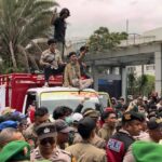 Doc. Mahasiswa Universitas Muhammadiyah Jakarta (UMJ) menurunkan muatan sampah dari dua truk di halaman Kantor Wali Kota Tangerang Selatan saat aksi unjuk rasa kedua, Kamis (8/1), sebagai bentuk protes terhadap krisis pengelolaan sampah di wilayah tersebut. (Sumber Foto: Warga TANGSEL).