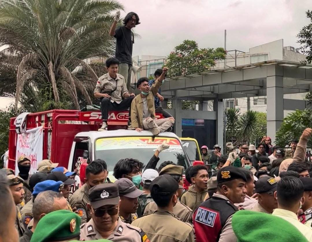 Doc. Mahasiswa Universitas Muhammadiyah Jakarta (UMJ) menurunkan muatan sampah dari dua truk di halaman Kantor Wali Kota Tangerang Selatan saat aksi unjuk rasa kedua, Kamis (8/1), sebagai bentuk protes terhadap krisis pengelolaan sampah di wilayah tersebut. (Sumber Foto: Warga TANGSEL).