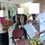 Doc. Muhammad Arifin, kuasa hukum Meilan Purnamawaty, berada di Kantor Pelayanan Kekayaan Negara dan Lelang (KPKNL) Jakarta III, Kamis (12/2/2026), sambil menunjukkan salah satu lembar dokumen yang berkaitan dengan permohonan penundaan lelang dua aset rumah dan ruko yang menjadi objek perkara. (Foto: Wilma).