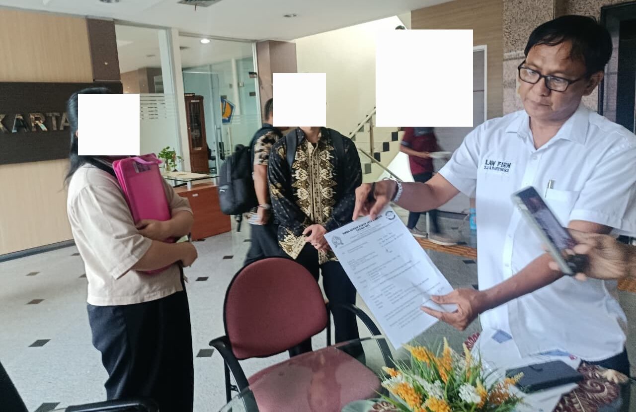 Doc. Muhammad Arifin, kuasa hukum Meilan Purnamawaty, berada di Kantor Pelayanan Kekayaan Negara dan Lelang (KPKNL) Jakarta III, Kamis (12/2/2026), sambil menunjukkan salah satu lembar dokumen yang berkaitan dengan permohonan penundaan lelang dua aset rumah dan ruko yang menjadi objek perkara. (Foto: Wilma).
