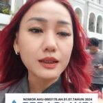 Doc. Harriani Bianca Daryana saat berada di depan gedung berlatar arsitektur klasik berwarna putih-abu, mengenakan busana abu-abu dengan rambut merah tergerai, dalam momen dokumentasi kegiatan FERADI WPI. Pada bagian bawah foto tertera identitas organisasi “FERADI WPI – Pusat Bantuan Hukum” beserta nomor AHU-0003170.AH.01.07.TAHUN 2024 sebagai penegasan legalitas lembaga.
