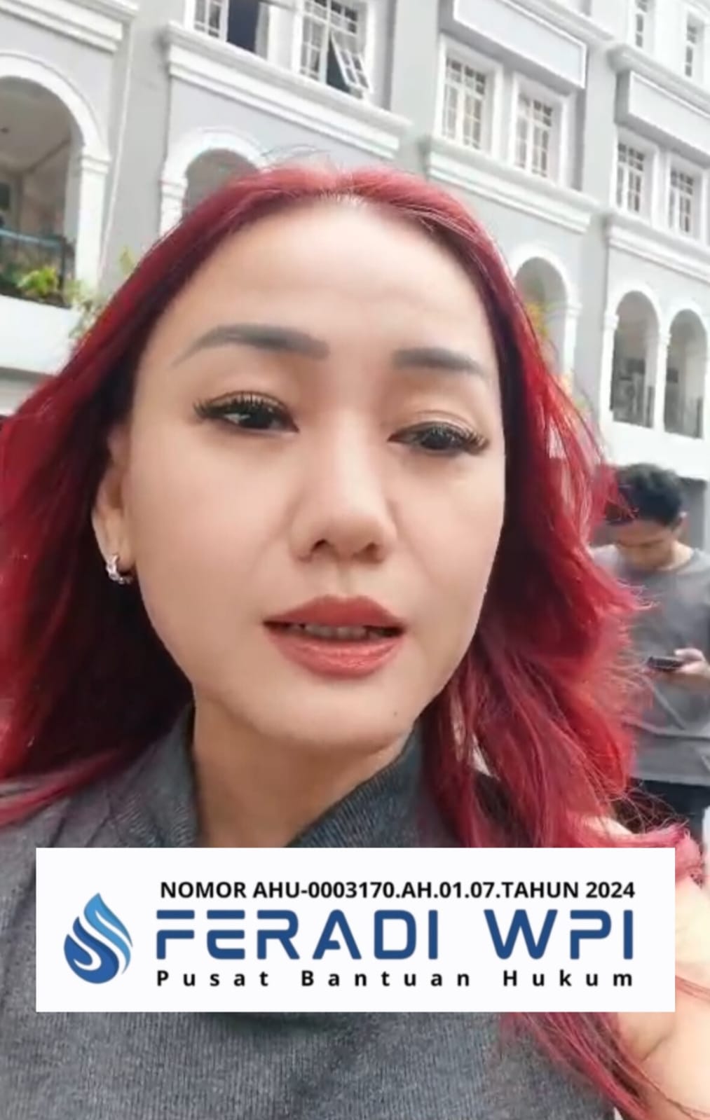 Doc. Harriani Bianca Daryana saat berada di depan gedung berlatar arsitektur klasik berwarna putih-abu, mengenakan busana abu-abu dengan rambut merah tergerai, dalam momen dokumentasi kegiatan FERADI WPI. Pada bagian bawah foto tertera identitas organisasi “FERADI WPI – Pusat Bantuan Hukum” beserta nomor AHU-0003170.AH.01.07.TAHUN 2024 sebagai penegasan legalitas lembaga.