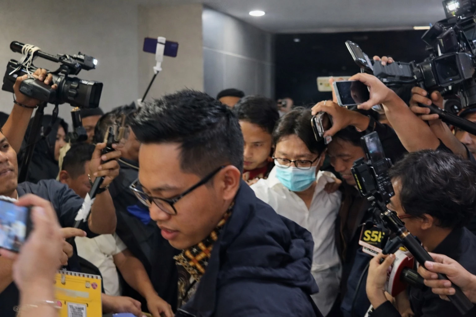Doc. Dokter Richard Lee berjalan keluar dari ruang pemeriksaan di Direktorat Reserse Kriminal Khusus Polda Metro Jaya, Jakarta, usai menjalani pemeriksaan terkait kasus dugaan pelanggaran perlindungan konsumen dalam produk kecantikan yang dipasarkan olehnya, Jumat (6/3/2026) malam. (Sumber: Periskop.id).