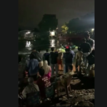 Doc. Tangkapan layar dari video dokumentasi memperlihatkan suasana di lokasi pencarian anak laki-laki yang dilaporkan tenggelam di Sungai Kayu Tangi, kawasan Parak Pasar Kasturi, Banjarmasin, Kamis (19/3/2026). Warga, relawan, dan aparat kepolisian tampak masih berada di sekitar bantaran sungai untuk memantau proses pencarian korban. (Sumber Foto: Tangkapan layar video warga).