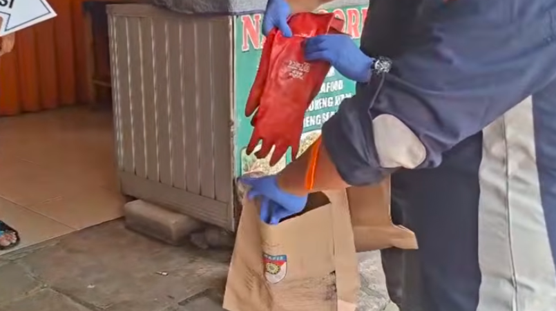 Doc. Petugas kepolisian memasukkan barang bukti berupa sarung tangan ke dalam kantong khusus barang bukti saat proses olah TKP lanjutan kasus kematian seorang pria yang ditemukan di dalam freezer kios ayam geprek di kawasan Perumahan Mega Regency, Desa Sukaragam, Kecamatan Serang Baru, Kabupaten Bekasi, sebelum dibawa untuk pemeriksaan lebih lanjut. (NR).