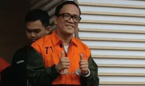 Doc. Immanuel Ebenezer alias Noel mengenakan rompi tahanan oranye dengan tangan terborgol usai ditetapkan sebagai tersangka dalam perkara dugaan pemerasan terkait pengurusan sertifikat dan lisensi Keselamatan dan Kesehatan Kerja (K3) di lingkungan Kementerian Ketenagakerjaan. (Sumber Foto: KPK).