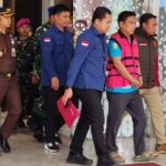 Doc. HS (inisial), yang menjabat sebagai Ketua Ombudsman RI, saat dibawa oleh petugas Kejaksaan Agung di lingkungan kantor Kejaksaan Agung untuk menjalani proses hukum lebih lanjut terkait penetapan status tersangka.