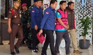 Doc. HS (inisial), yang menjabat sebagai Ketua Ombudsman RI, saat dibawa oleh petugas Kejaksaan Agung di lingkungan kantor Kejaksaan Agung untuk menjalani proses hukum lebih lanjut terkait penetapan status tersangka.