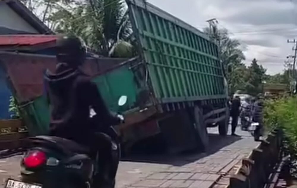 Doc. Sebuah truk bermuatan berat tampak terperosok saat melintasi jembatan kecil di Jalan Mantuil, Banjarmasin Selatan, Kamis (9/4/2026), diduga akibat beban berlebih yang memicu kerusakan pada badan jalan dan akses warga.