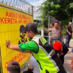 Doc. Petugas memasang baliho peringatan di kawasan perlintasan kereta api liar jalur Tebet–Cawang, Jakarta Selatan, sebagai bagian dari upaya sosialisasi keselamatan dan rencana penertiban akses penyeberangan tidak resmi.