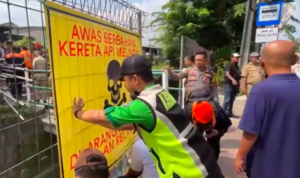 Doc. Petugas memasang baliho peringatan di kawasan perlintasan kereta api liar jalur Tebet–Cawang, Jakarta Selatan, sebagai bagian dari upaya sosialisasi keselamatan dan rencana penertiban akses penyeberangan tidak resmi.