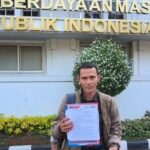 Doc. Sudirlam menunjukkan sebuah dokumen saat menyampaikan keterangan terkait perjuangan masyarakat transmigrasi Air Balui di Jakarta, Jumat (22/5/2026).