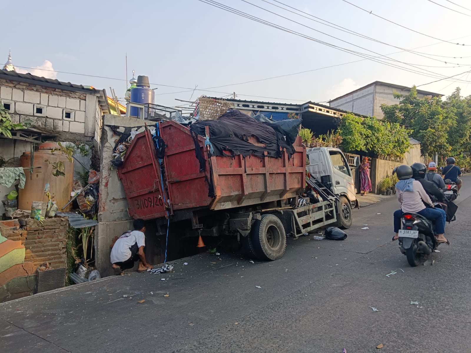 Doc. Truk pengangkut sampah milik DLH Kota Semarang yang terlibat kecelakaan tunggal terlihat berada di lokasi kejadian setelah menabrak pagar rumah warga di Jalan Untung Suropati, Kampung Bambankerep, Kecamatan Mijen, Kota Semarang, Minggu (14/6/2026).