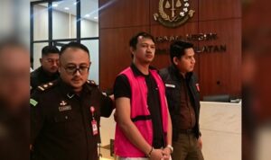 Doc. Seorang terduga tersangka kasus dugaan tindak pidana korupsi terlihat mengenakan rompi tahanan saat dibawa petugas Kejaksaan Agung untuk menjalani pemeriksaan lanjutan di Jakarta. Proses pengawalan dilakukan ketat oleh petugas sesuai prosedur penyidikan yang berlaku, sementara yang bersangkutan menuju kendaraan tahanan untuk pemeriksaan lebih lanjut.