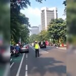 Doc. Tangkapan layar rekaman video yang beredar di media sosial memperlihatkan seorang anggota kepolisian berdiri di tengah badan jalan saat melakukan pengaturan lalu lintas sebelum insiden dugaan pemukulan terhadap kaca ambulans di kawasan Tanah Abang, Jakarta Pusat, Senin (6/7/2026).