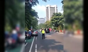 Doc. Tangkapan layar rekaman video yang beredar di media sosial memperlihatkan seorang anggota kepolisian berdiri di tengah badan jalan saat melakukan pengaturan lalu lintas sebelum insiden dugaan pemukulan terhadap kaca ambulans di kawasan Tanah Abang, Jakarta Pusat, Senin (6/7/2026).