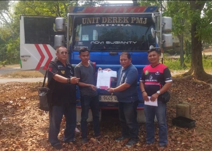 Doc. Ketua PBH FERADI WPI Area Subang II, Ass. Adv. Benni Rusli, C.PFW., C.MDF., C.JKJ., C.FTAX., bersama pengemudi kendaraan saat menerima dan memegang dokumen terkait pengembalian mobil derek yang sebelumnya dititipkan sebagai barang bukti di Kejaksaan Negeri Subang. Dokumentasi dilakukan di depan kendaraan setelah proses pengembalian kepada pemilik selesai.