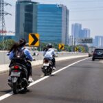 Doc. Dua pengendara sepeda motor melintas di ruas jalan bebas hambatan, menggambarkan situasi kendaraan roda dua yang masuk ke jalur tol sebagaimana dibahas dalam pemberitaan.