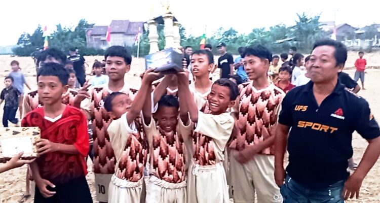 Doc. Salah satu peserta Turnamen Sepak Bola U14 Dronjong 2026 mengangkat trofi setelah pertandingan final di Stadion GBK, Dronjong, Pemalang, Minggu (4/10/2026). Bima FC dari RT 05 keluar sebagai juara setelah mengalahkan Real JR FC RT 03 dengan skor 2-0.