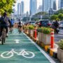 Doc. lustrasi jalur sepeda di kawasan perkotaan Jakarta yang memperlihatkan pesepeda melintas di jalur khusus di tengah kepadatan lalu lintas kendaraan bermotor. Ilustrasi ini menggambarkan pentingnya evaluasi, pemeliharaan, dan pengawasan jalur sepeda untuk mendukung keselamatan serta memastikan fasilitas transportasi tersebut berfungsi sesuai peruntukannya. Foto ilustrasi: KawanJariNews.com