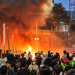 Doc. Kobaran api dan kepulan asap terlihat di tengah kerumunan warga saat kericuhan di kawasan Manggarai, Jakarta Selatan, Minggu (18/10/2026). Peristiwa tawuran tersebut dilaporkan berdampak pada sejumlah tempat usaha warga, termasuk sebuah konter telepon seluler yang mengalami kerusakan dan penjarahan.