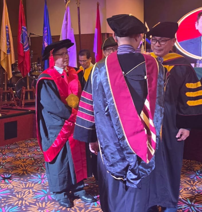 Doc. Pdt. Dr. Lusak Andrews M. Butar-butar, S.Th., M.Th., dalam momentum wisuda doktoral teologi, Sabtu (24/10/2026). Disertasinya mengangkat tema polarisasi Gereja Injili dan Ekumenikal di wilayah DKI Jakarta melalui pendekatan interdisipliner sosiologi keamanan nasional, dengan penekanan pada pentingnya kesatuan gereja, dialog, dan kerukunan untuk merawat persatuan bangsa di tengah keberagaman.